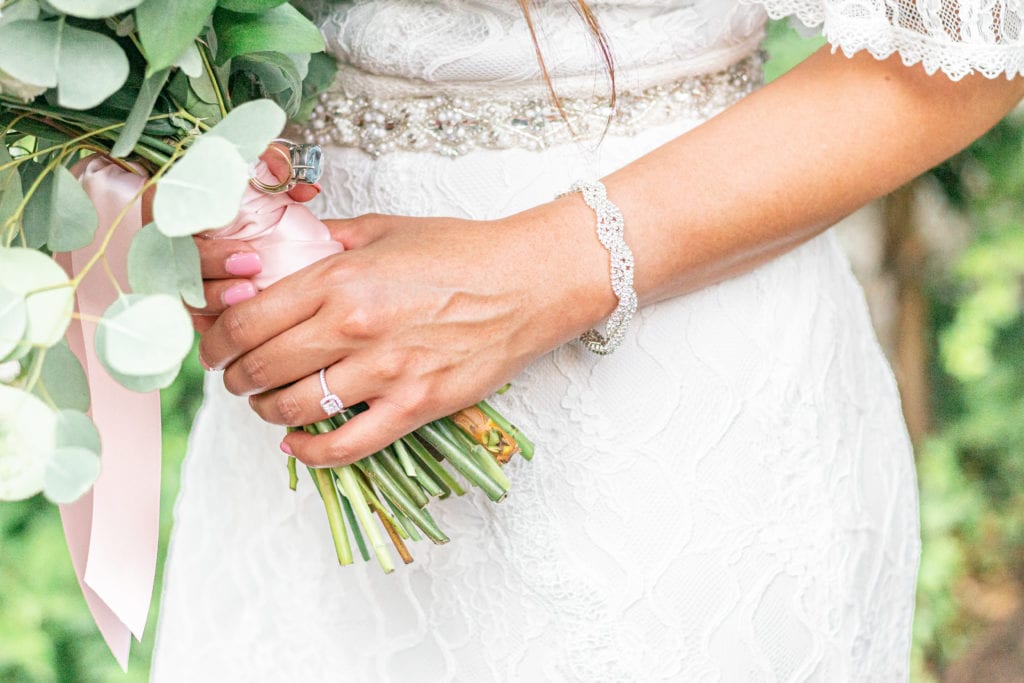 A detail photo of a bride wearing a diamond bracelet.