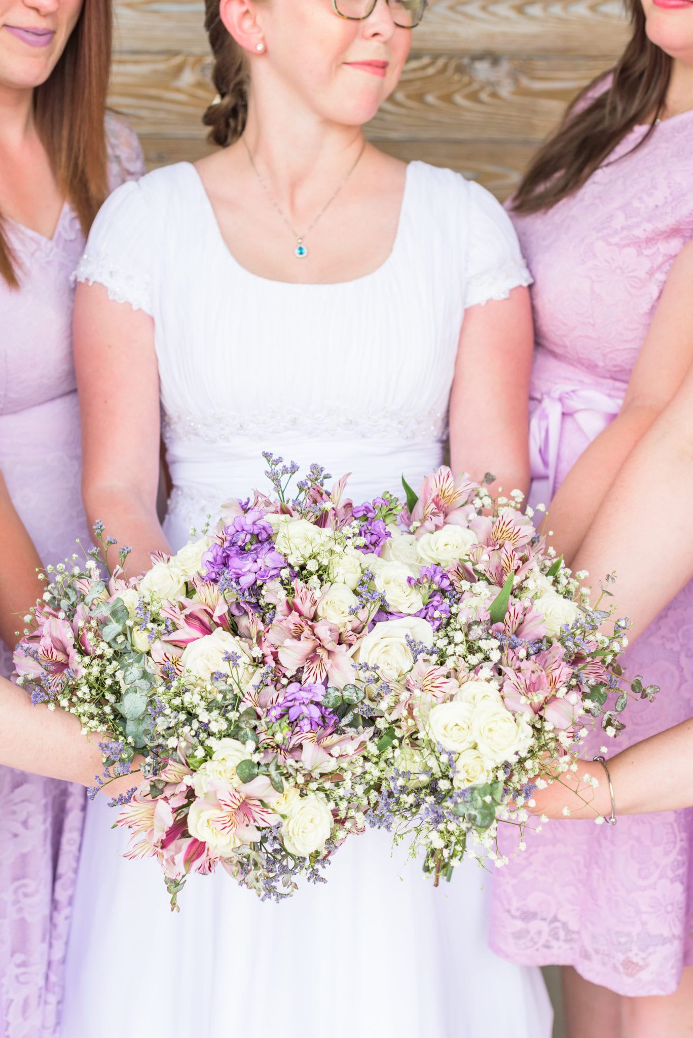A flattering wedding pose that shows bridesmaids laughing and all of the flowers.
