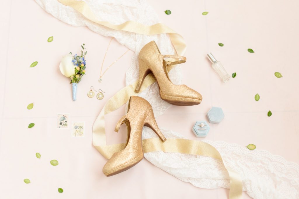 Gold shoes and gold ribbon in this flat lay photo.