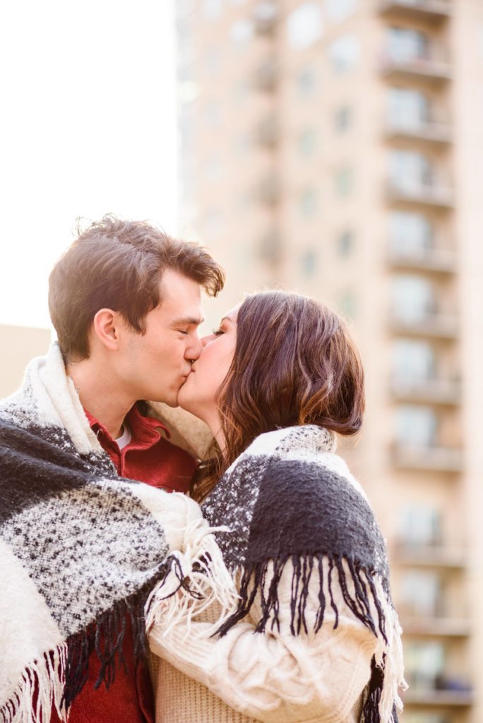A happily engaged couple kisses at Romare Bearden Park in Uptown Charlotte.