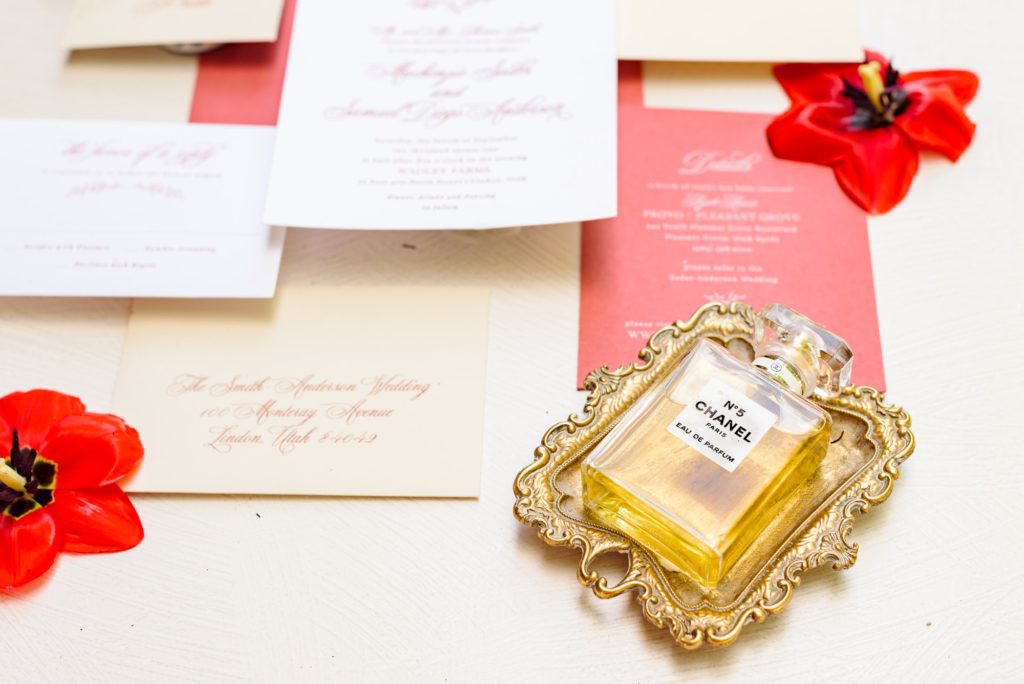 Photos of wedding invites with a Chanel perfume bottle.