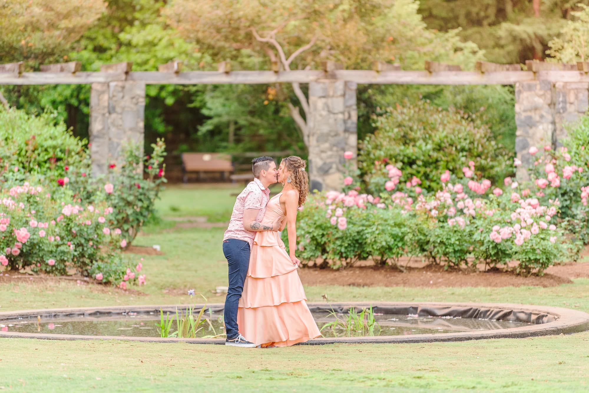 Two girls dance in the middle of the garden for their spring engagement photos.