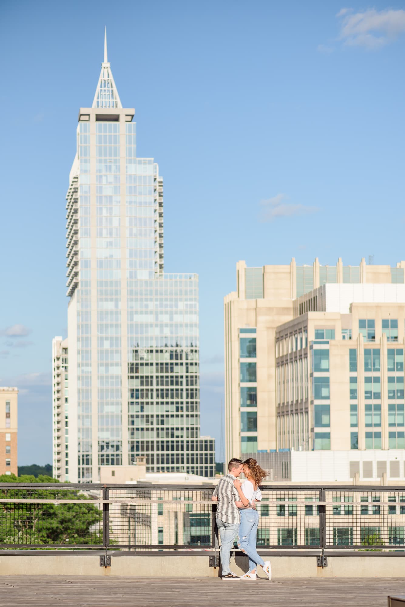 Spring engagement photos in front of the North Carolina skyline.