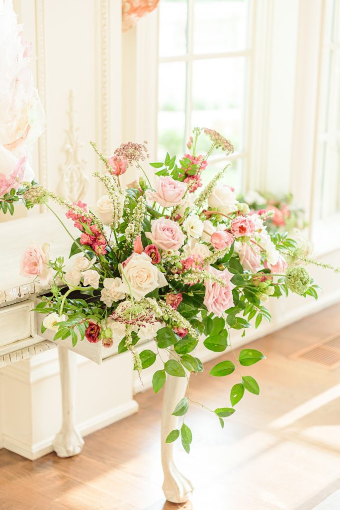 Pink and white floral wedding decor cascades out of the open drawer of this vintage dresser.