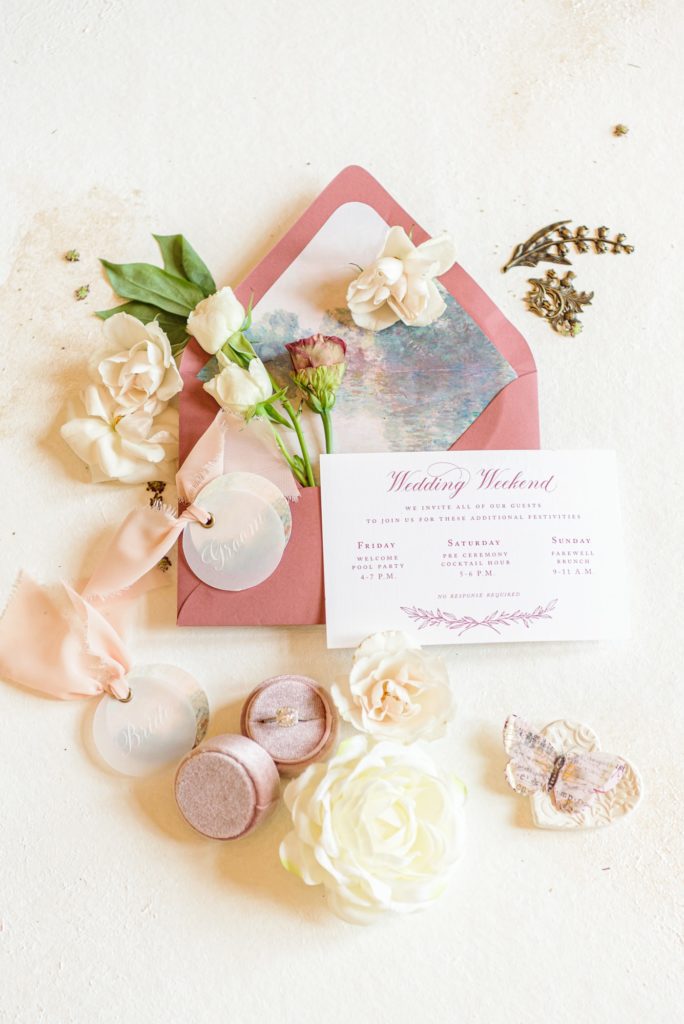 A wedding invitation with flowers, painted to match the pink colors of this elegant mansion wedding.