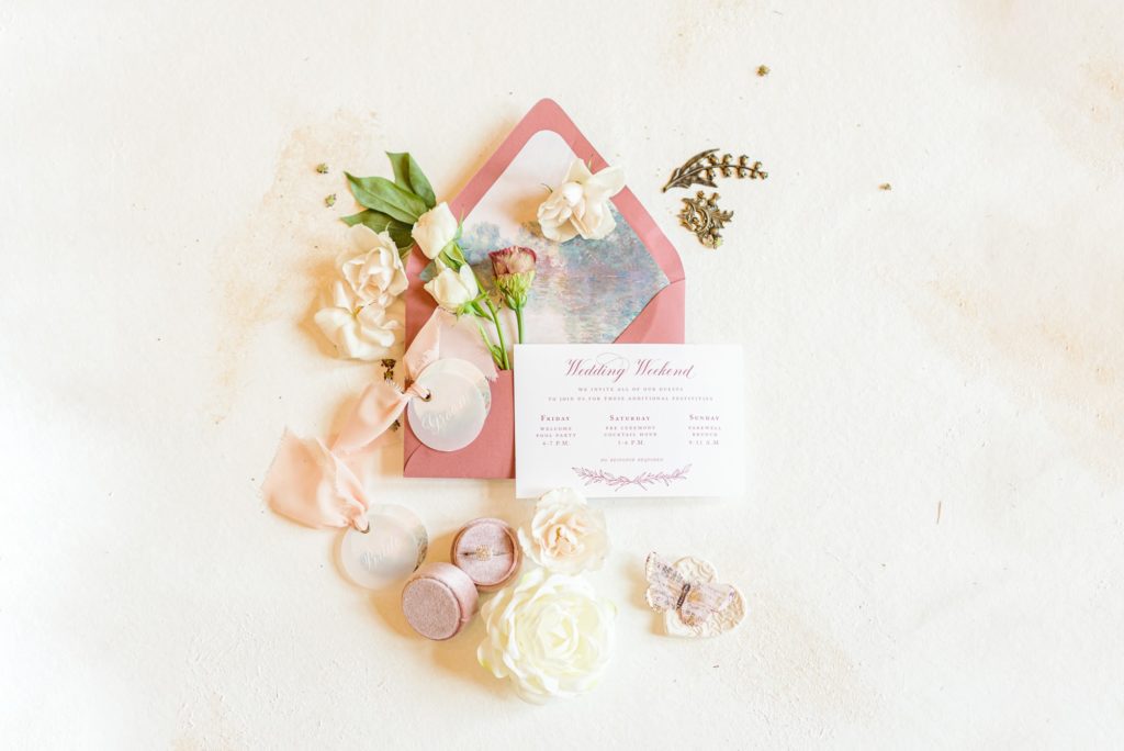 Photo of pink wedding invites with flowers coming out of the envelope.