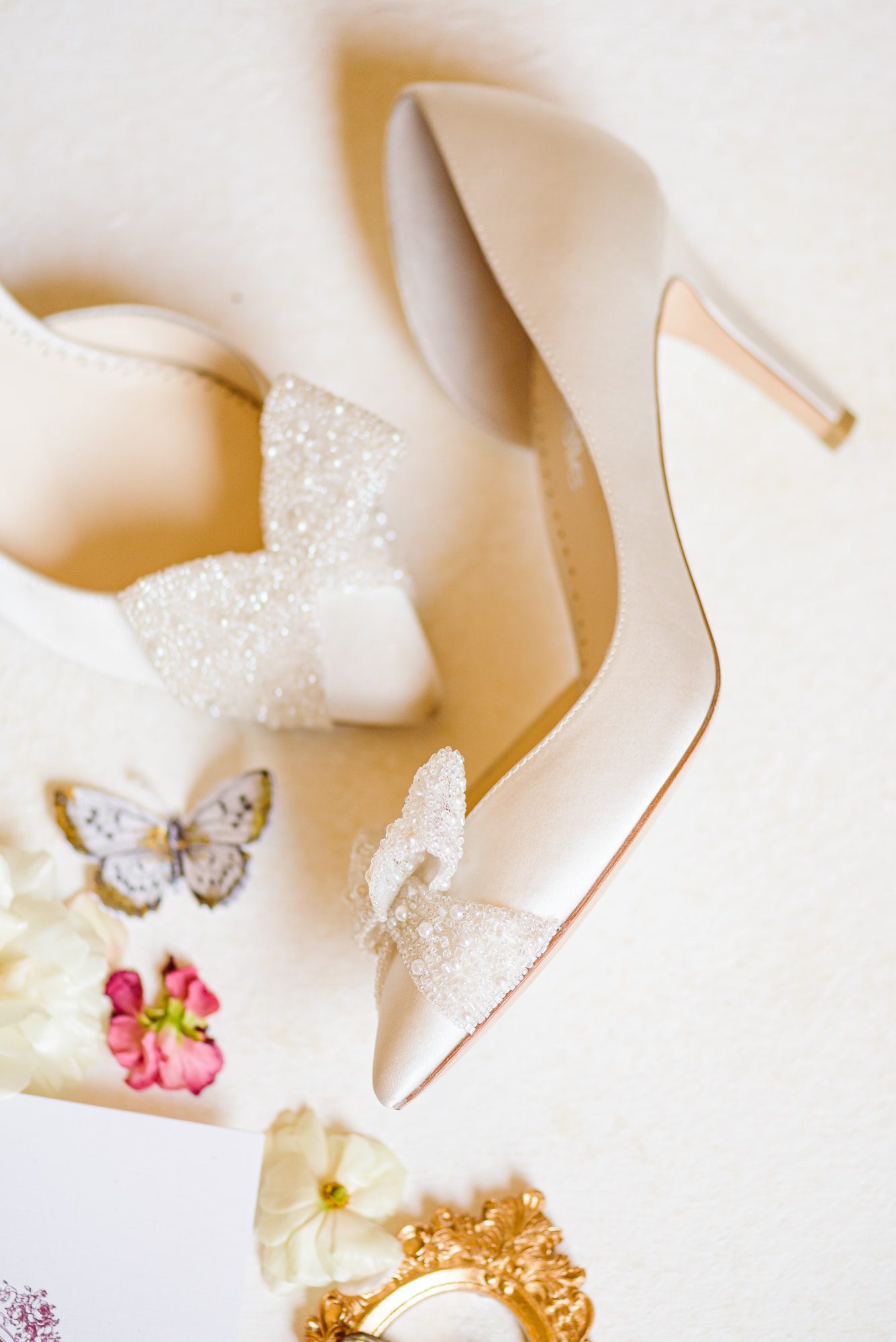 Beautiful satin shoes with bows tied on them fit the theme of this elegant mansion wedding.