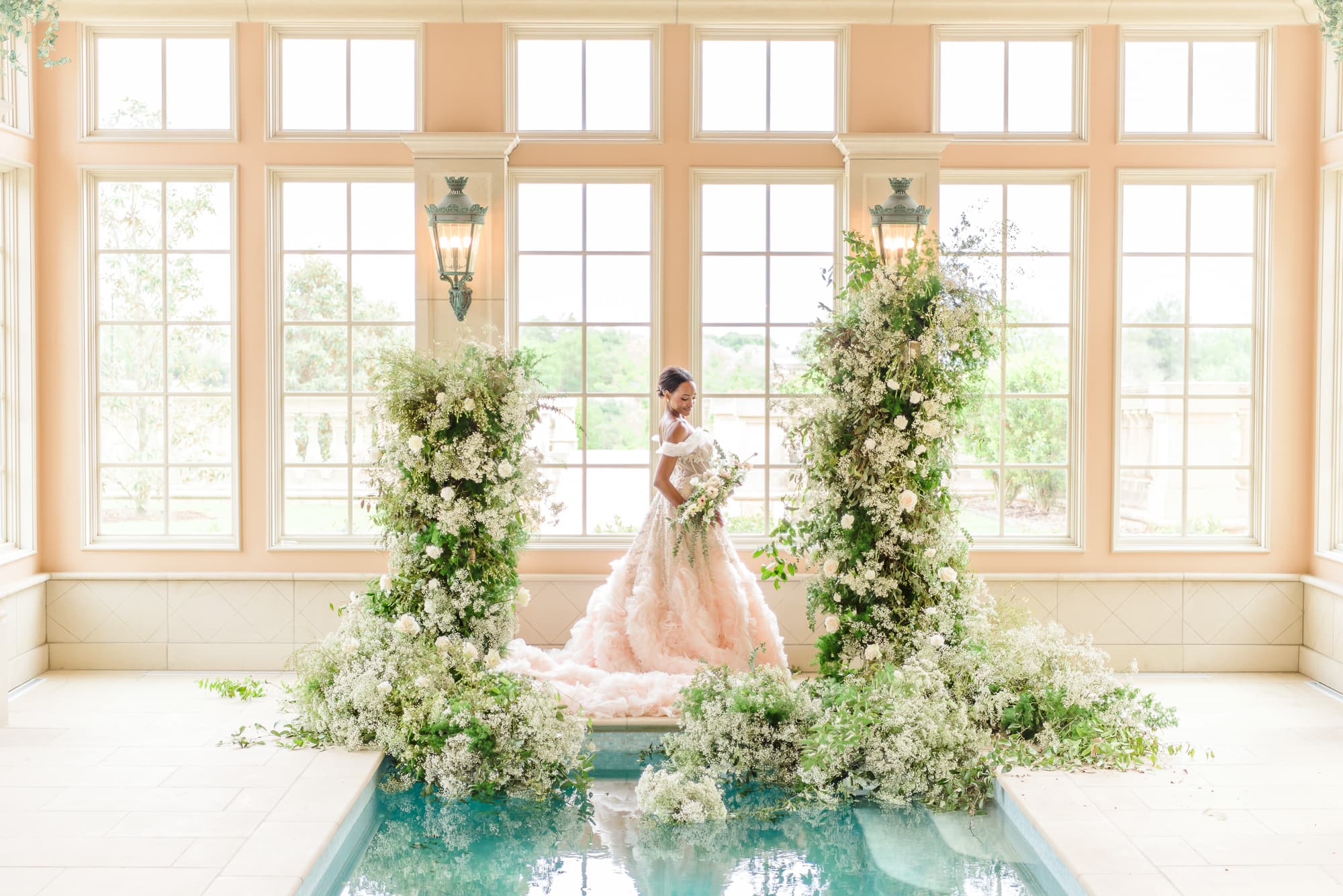 This poolside picture idea has an archway of flowers at the edge of the pool.