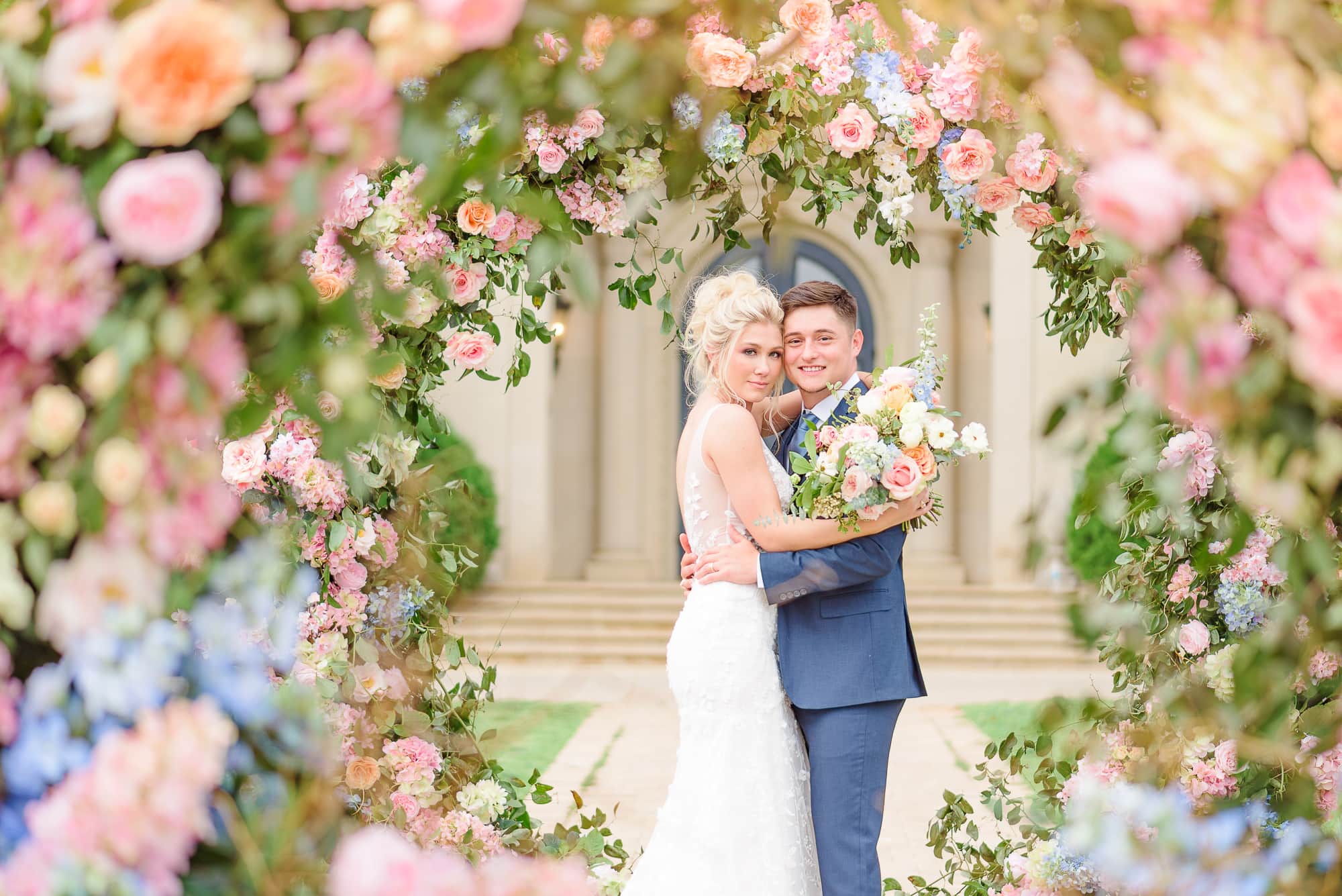 Their backdrop is dripping with flowers, and it creates a circle which we can see the bride and groom through.