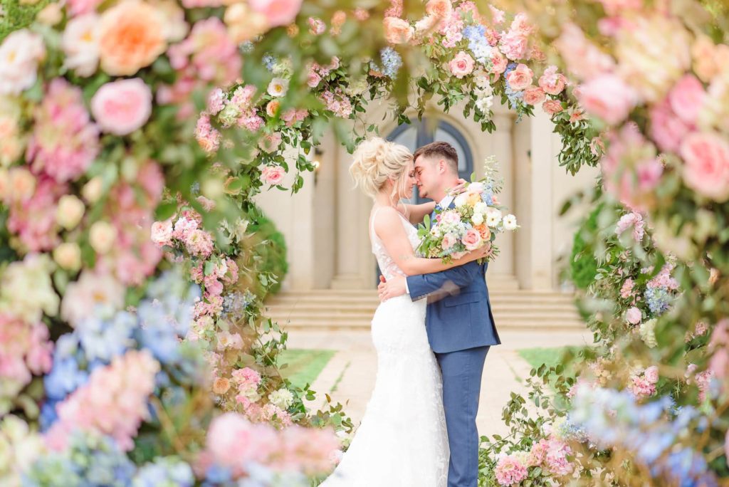 The wedding backdrop with flowers make this bride and groom look like they're surrounded in a ring of flowers.