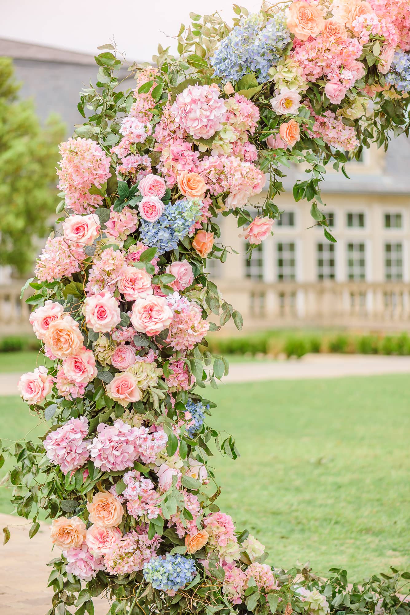 A closeup photo of this wedding backdrop with flowers in summer colors.