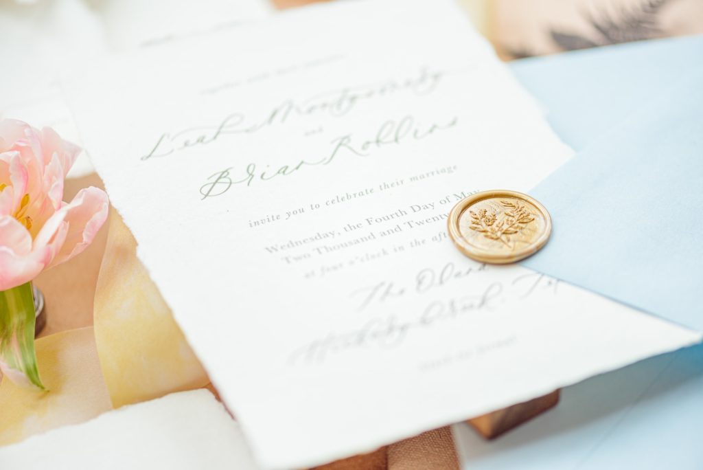 Wedding invitation photos with wax seals on the invite.