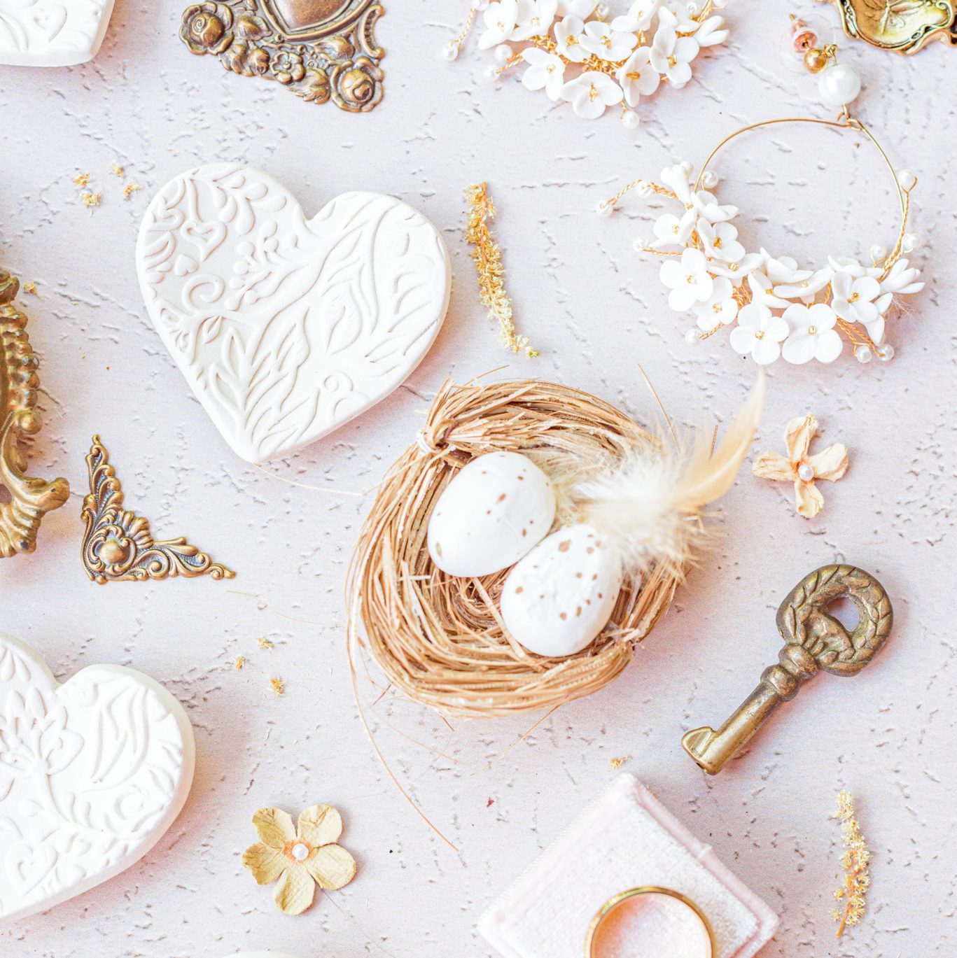 Photos of your wedding invites can include small trinkets, like this tiny bird's nest and vintage key.