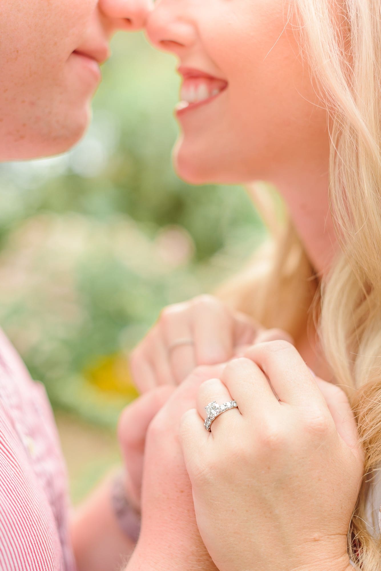 A beautiful engagement ring sits on Danielle's finger at their Charlotte rose garden engagement session.