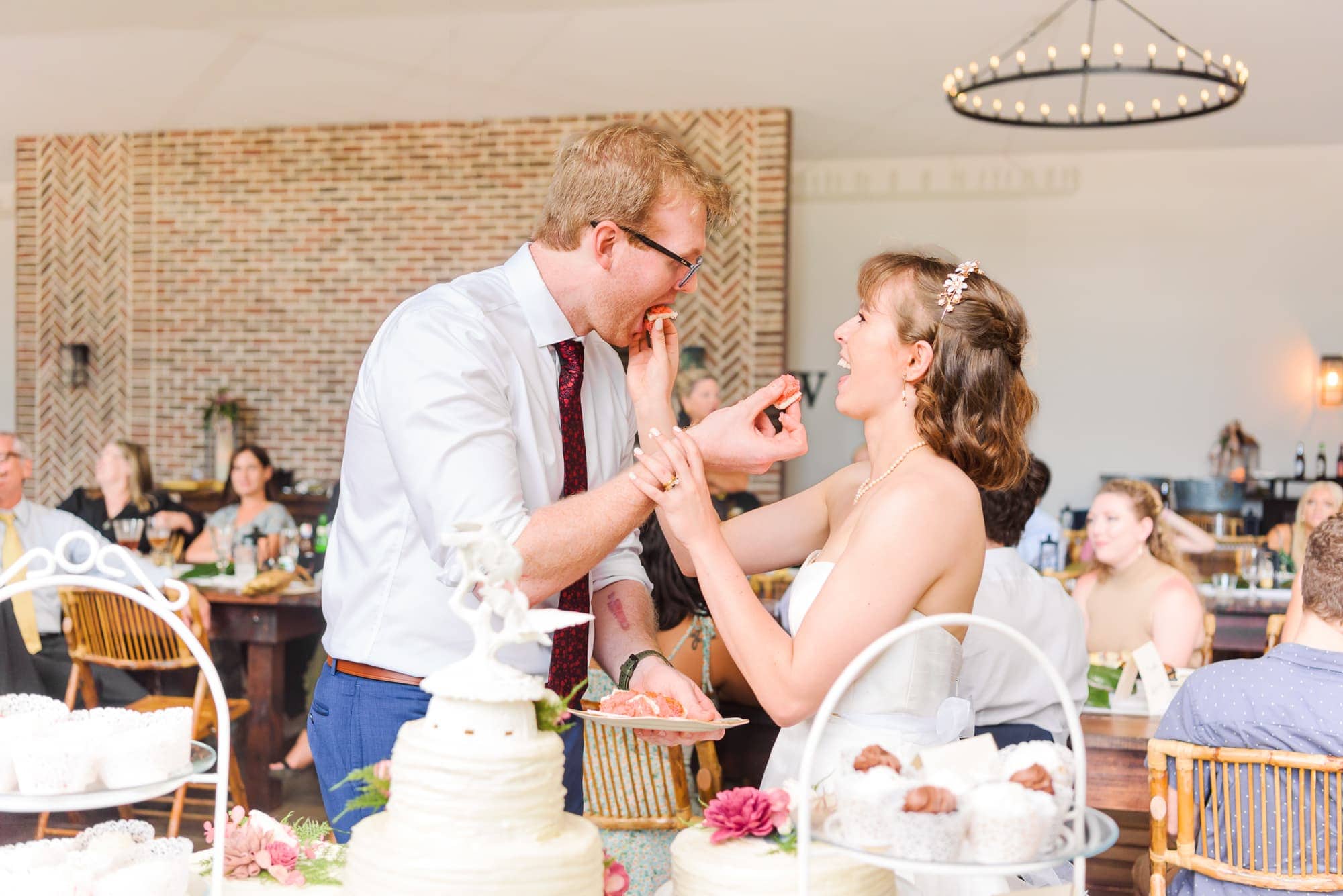 The bride and groom feed each other cake during their reception at Delaney Ridge wedding venue.