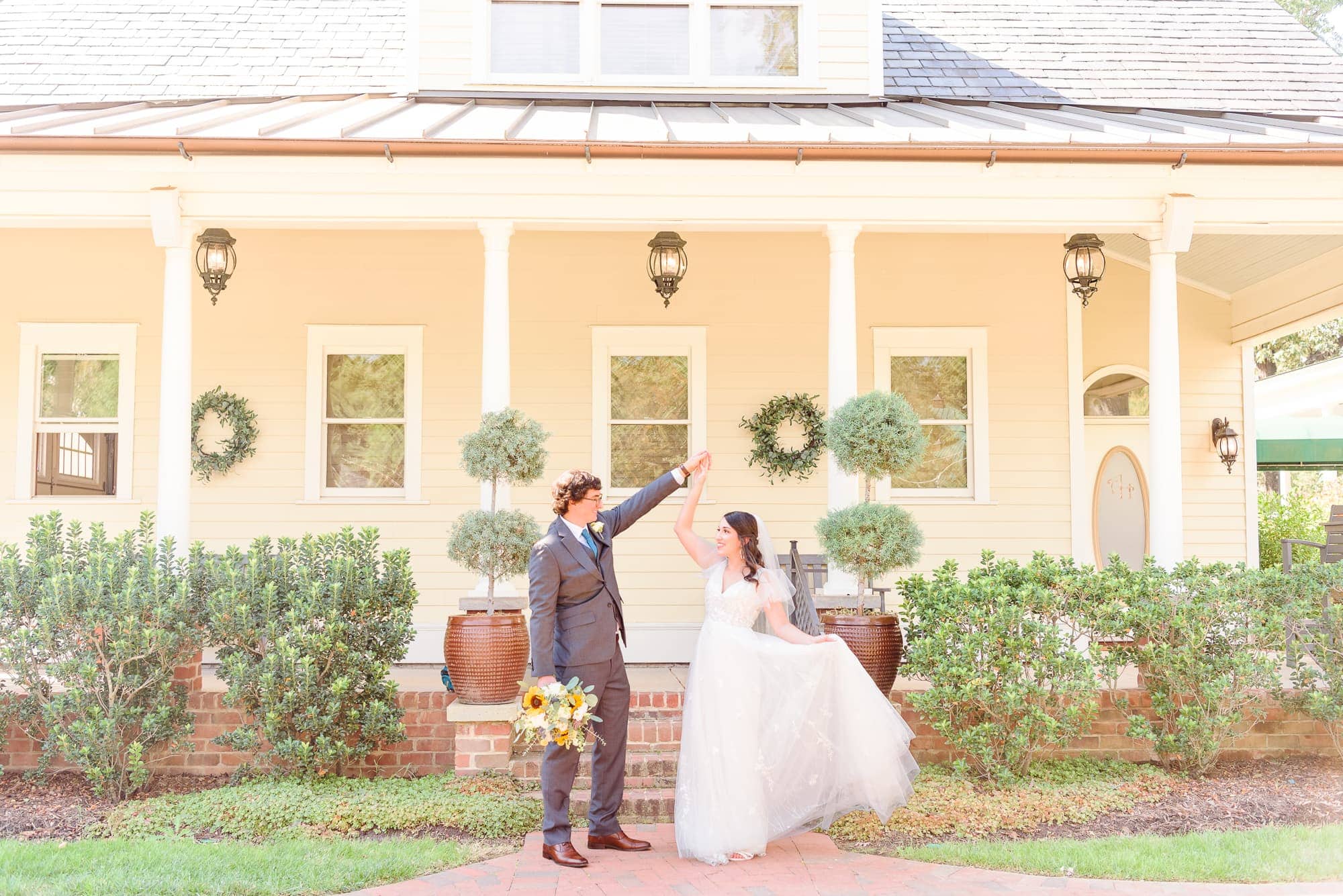 The bride and groom dance together in front of the bridal suite house at Alexander Homestead.