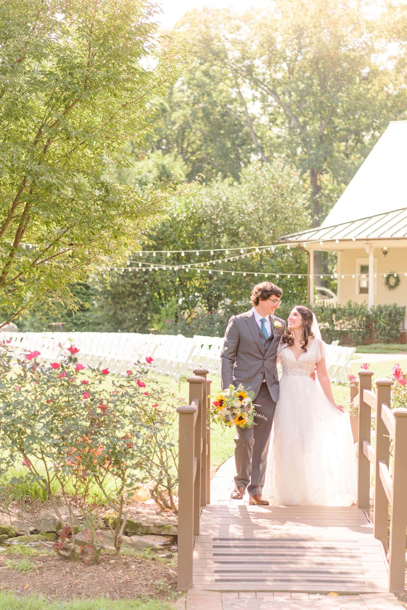 Natalie and Tommy walk together across the small bridge outside of Charlotte's mansion venue, Alexander Homestead.