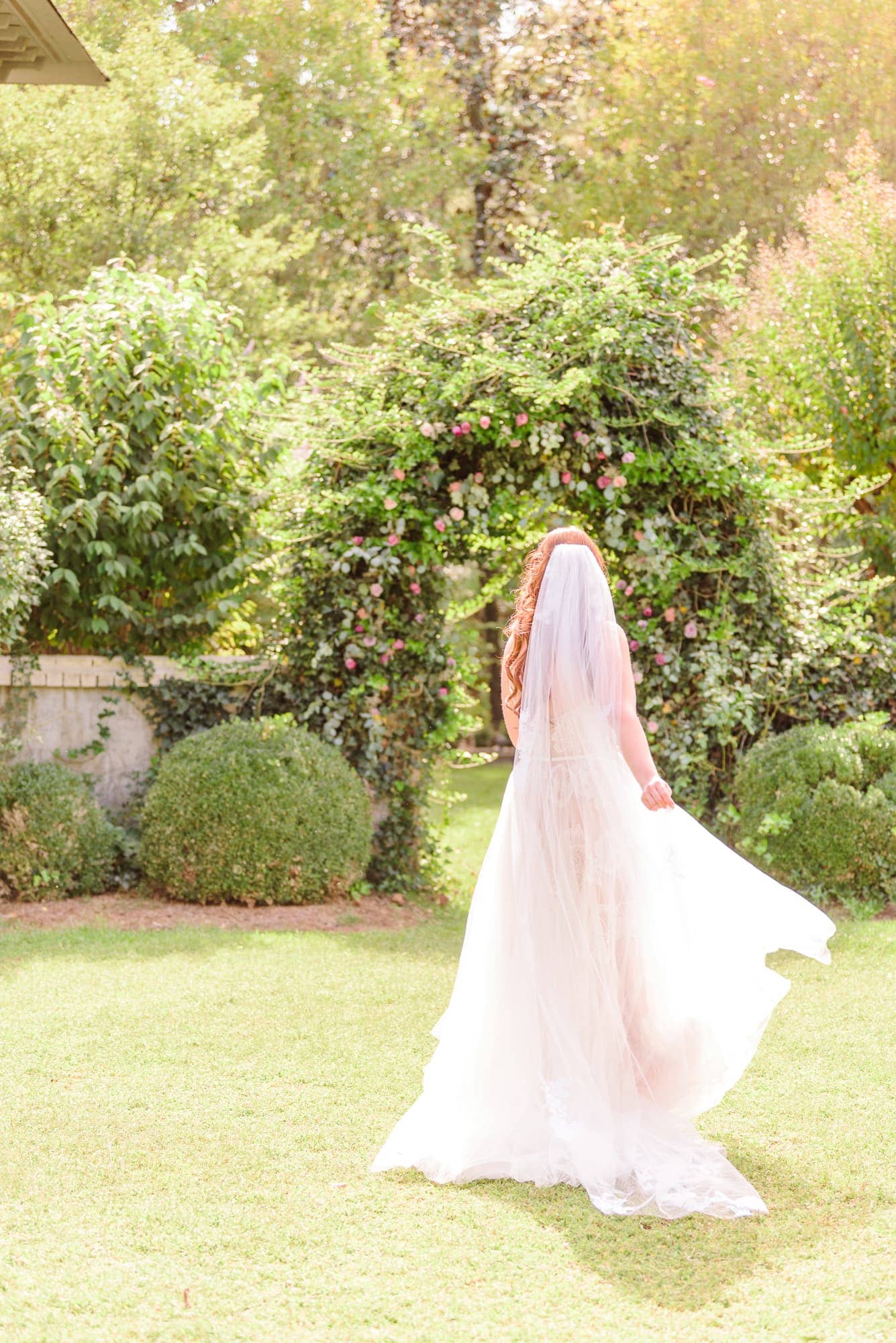 Olivia runs towards the floral archway on the grounds of the Key Rose Estate venue.