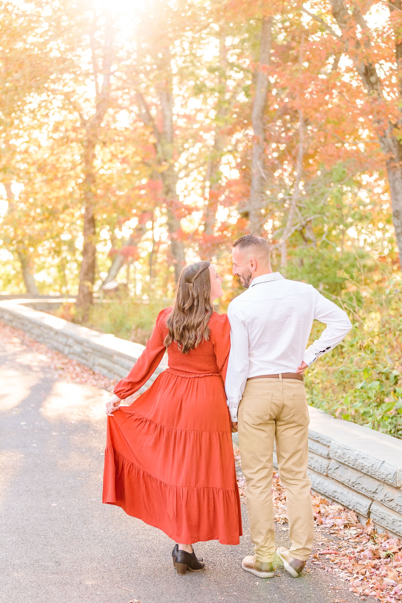Alicia and Joey walk through the colorful trees during their fall engagement photos in North Carolina.