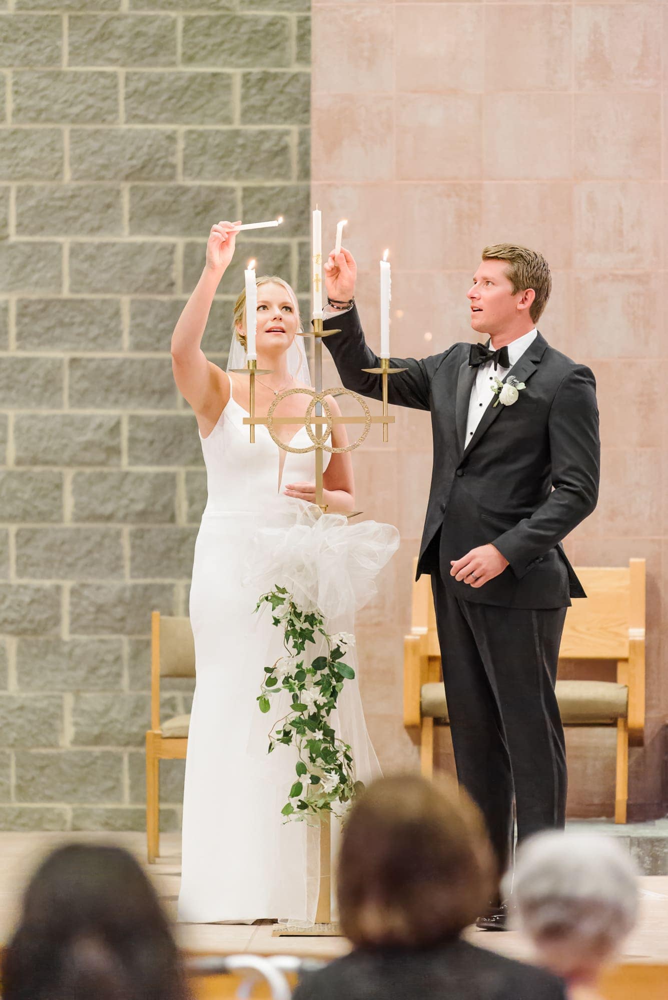 Lauren and Casey light the unity candle at their Catholic ceremony before heading over to their reception at the Longview Country Club in Charlotte.