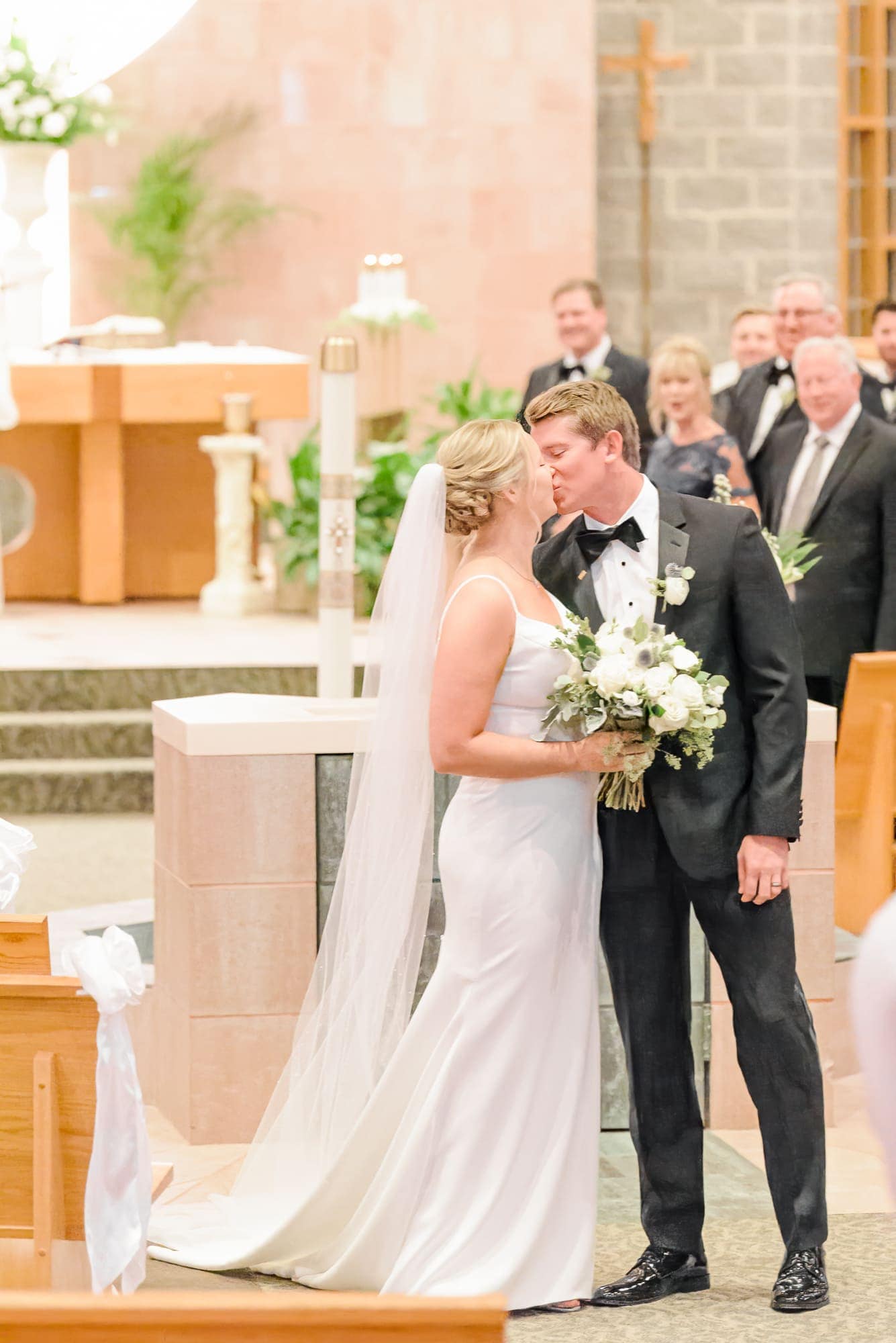 The bride and groom share one last kiss as they walk out of the church on the way to their Charlotte reception at the Longview Country Club.