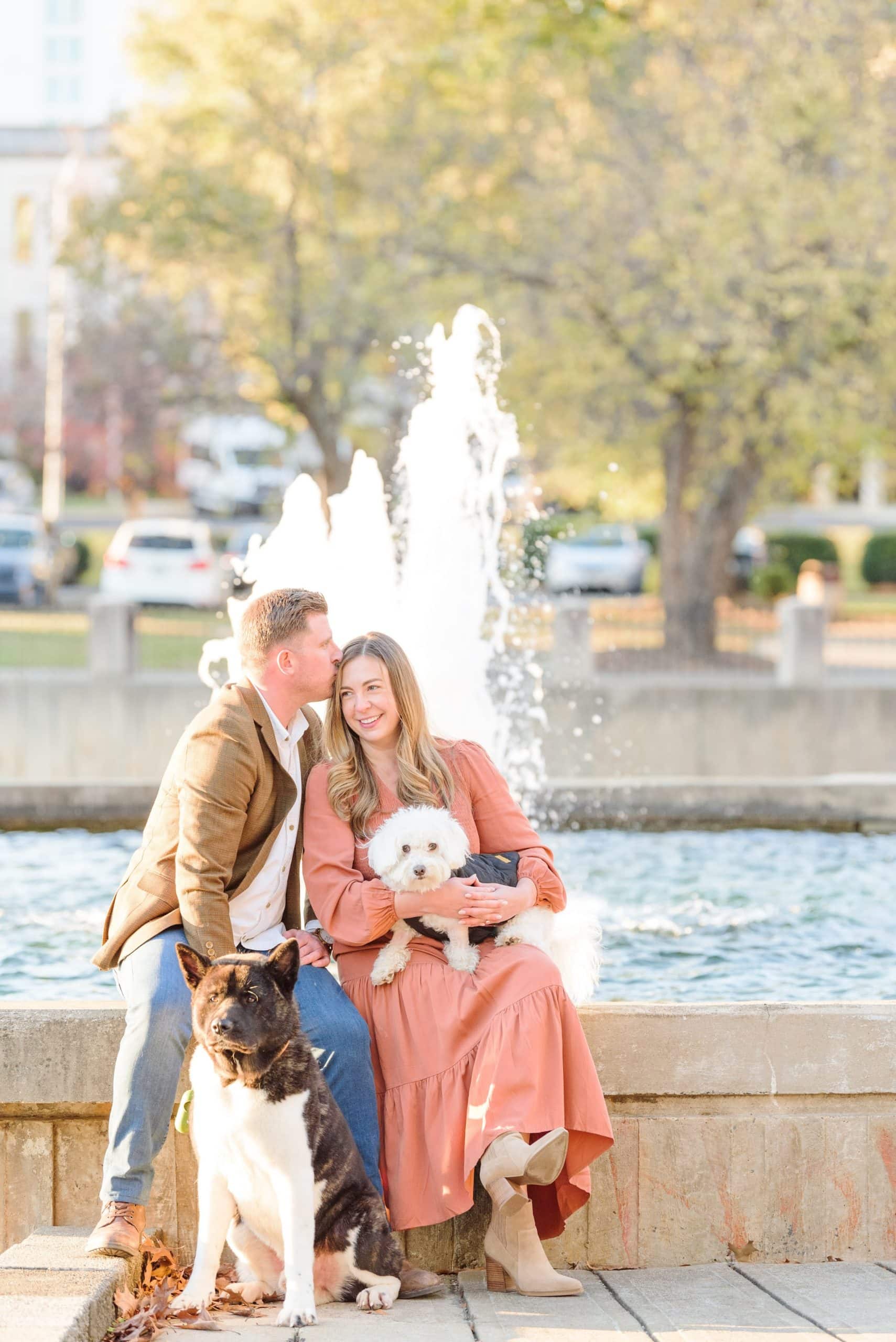 Kati and Curtis sit on the edge of a fountain during their city engagement photos.