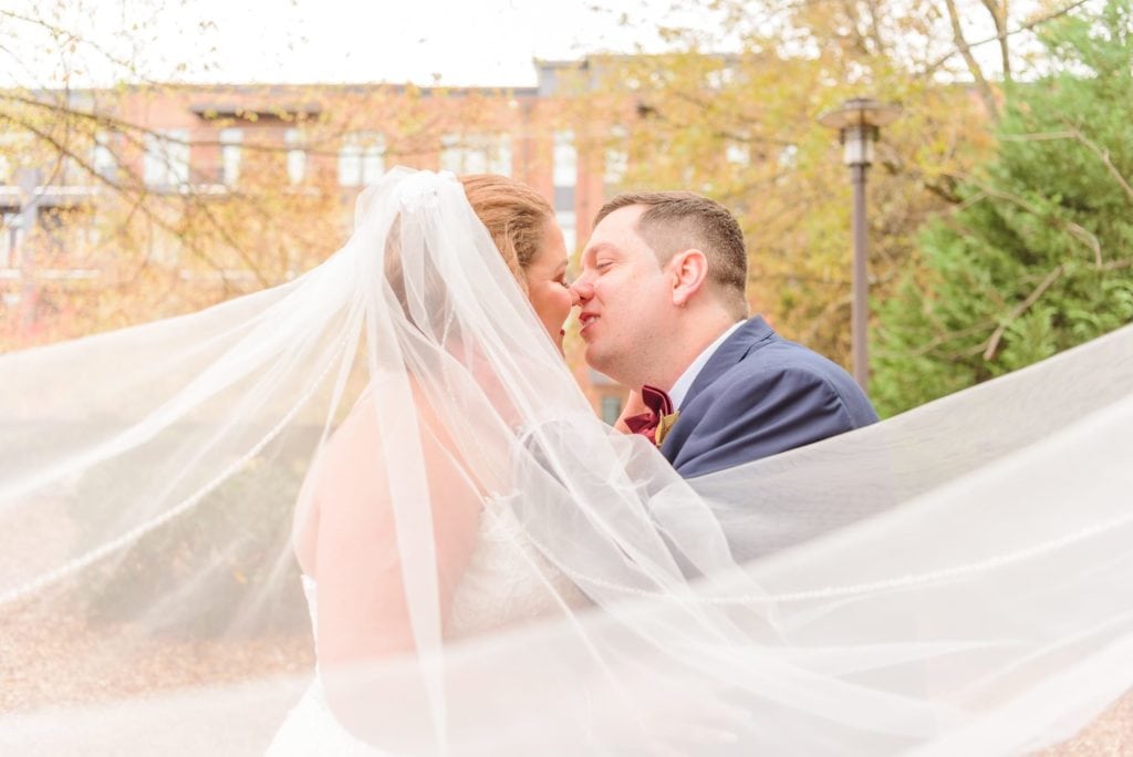 A bride and groom kiss under their veil at the Charles Mack Citizen Center in Mooresville, North Carolina.