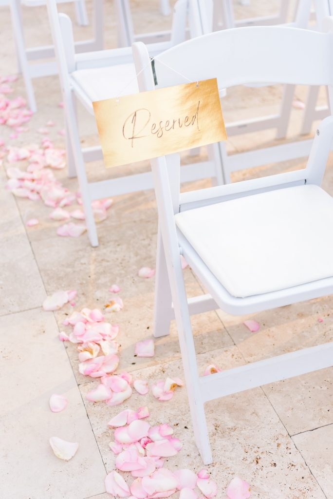 Hollywood themed wedding decor at the ceremony with gold "reserved" signs on the front row chairs.