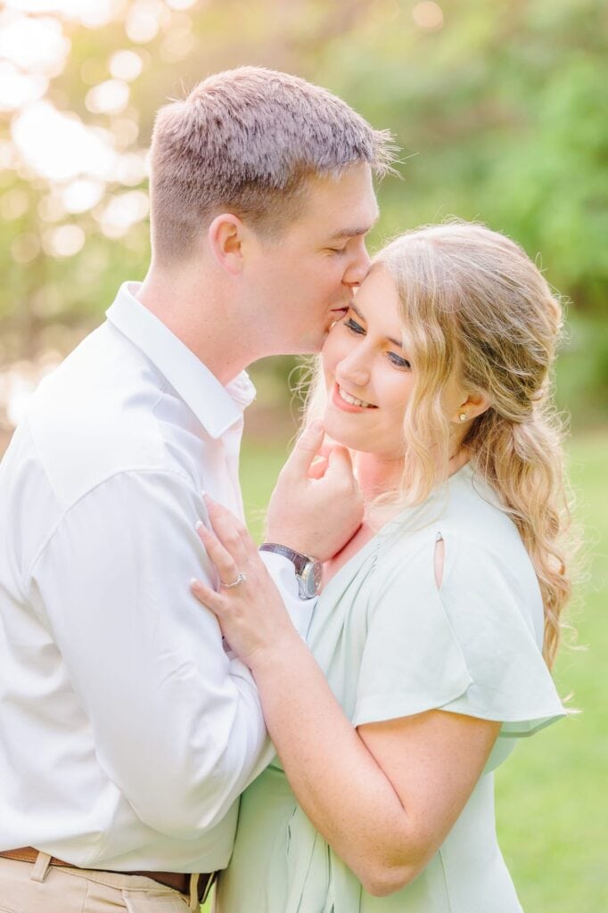 Conor kisses the side of Becca's forehead at the Latta Nature Preserve for their engagement photos.