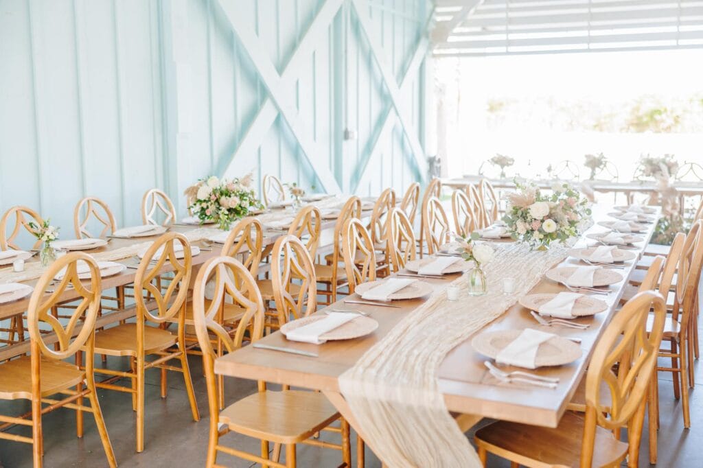 A North Carolina beach wedding with seafoam walls, wood chairs, and beige table runners.