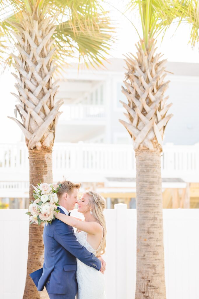 Spencer and Dave go in for a kiss on the beach at their North Carolina wedding.