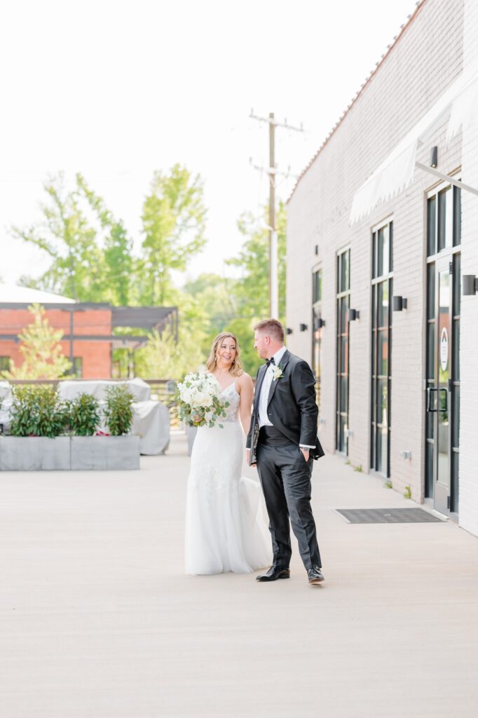 The bride and groom walk outside the doors of the Ruth wedding venue in Charlotte, NC.