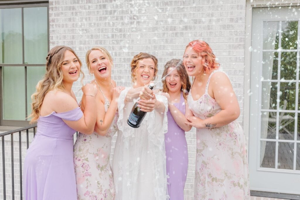 Sophie pops champagne with her bridesmaids out on the Bradford's balcony before her wedding.