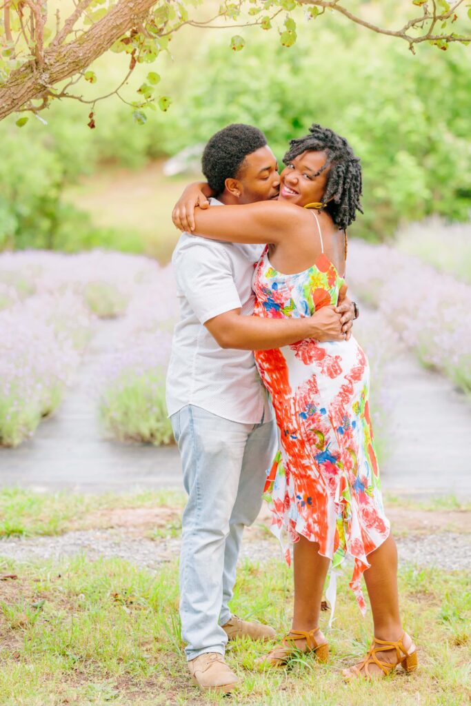 LaVianca smiles at the camera as Shakim hugs her in front of the lavender farm in this beautiful NC lavender field.