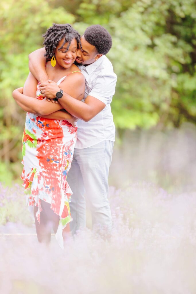 LaVianca and Shakim hold each other at the NC lavender farms, and purple lavender can be seen at their feet and in front of the camera.