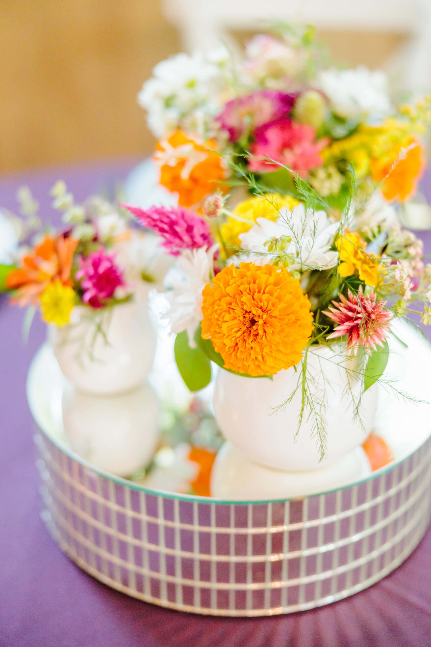 Bright orange flowers sit on a disco riser, keeping in theme for this 70s wedding.