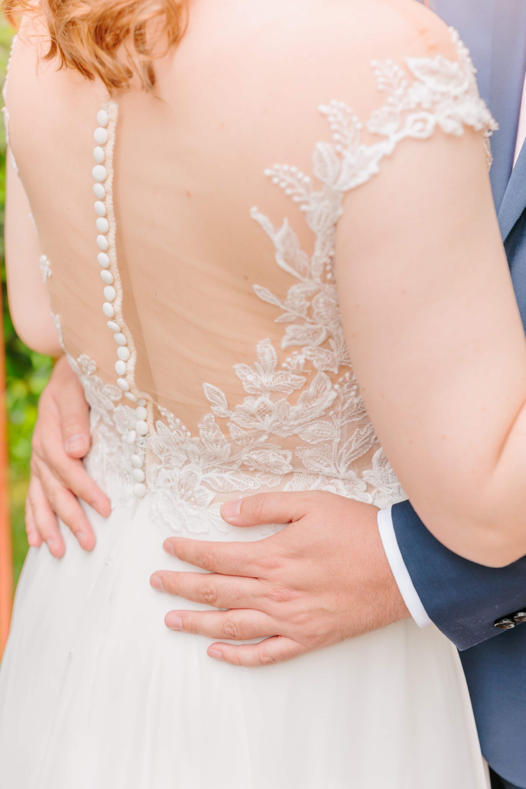 Intricate lace details adorn the back of this bride's dress as she waits for her Greensboro wedding to begin.