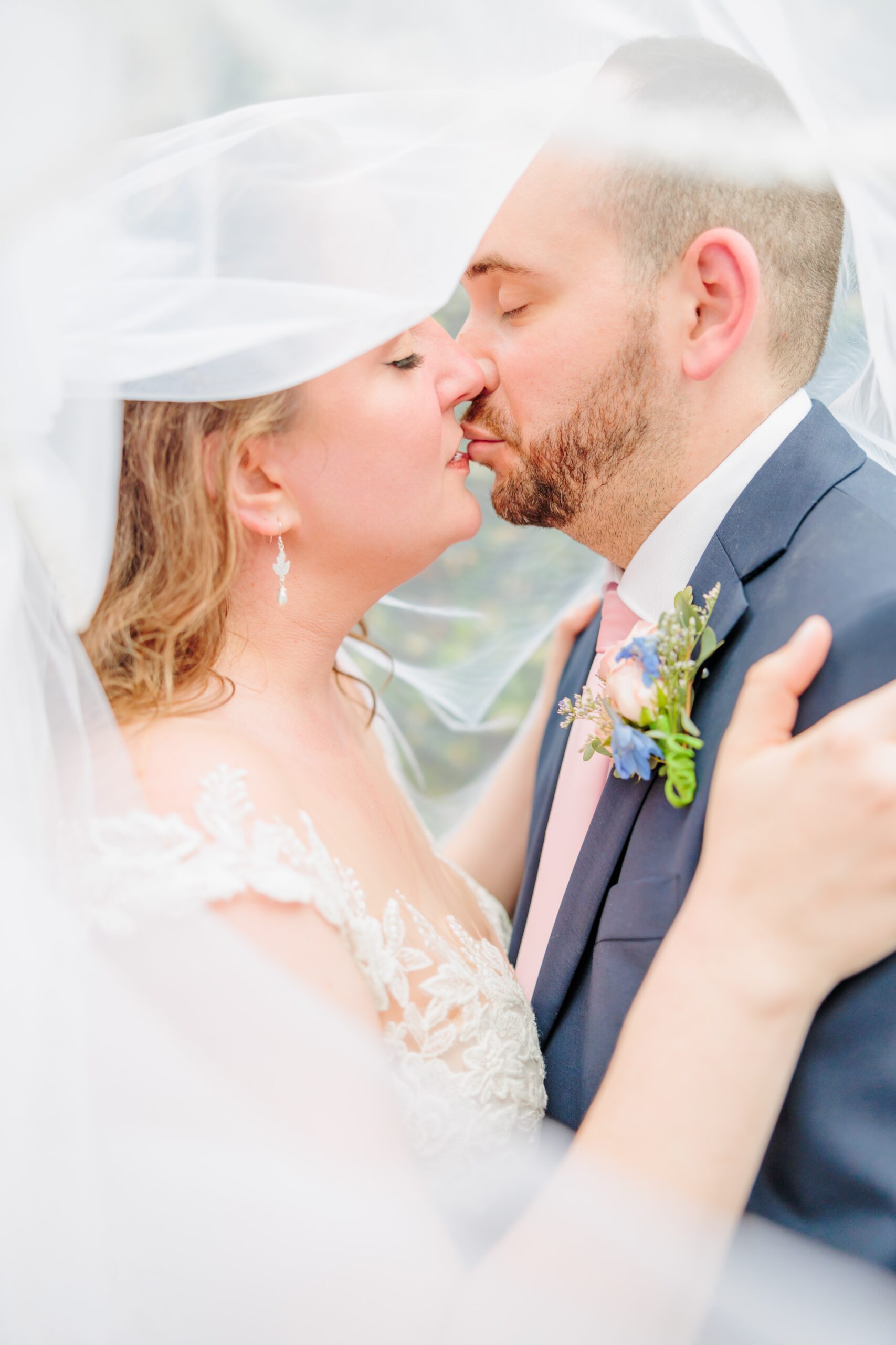 Emelia and Wakefield kiss under their veil after their Greensboro wedding.