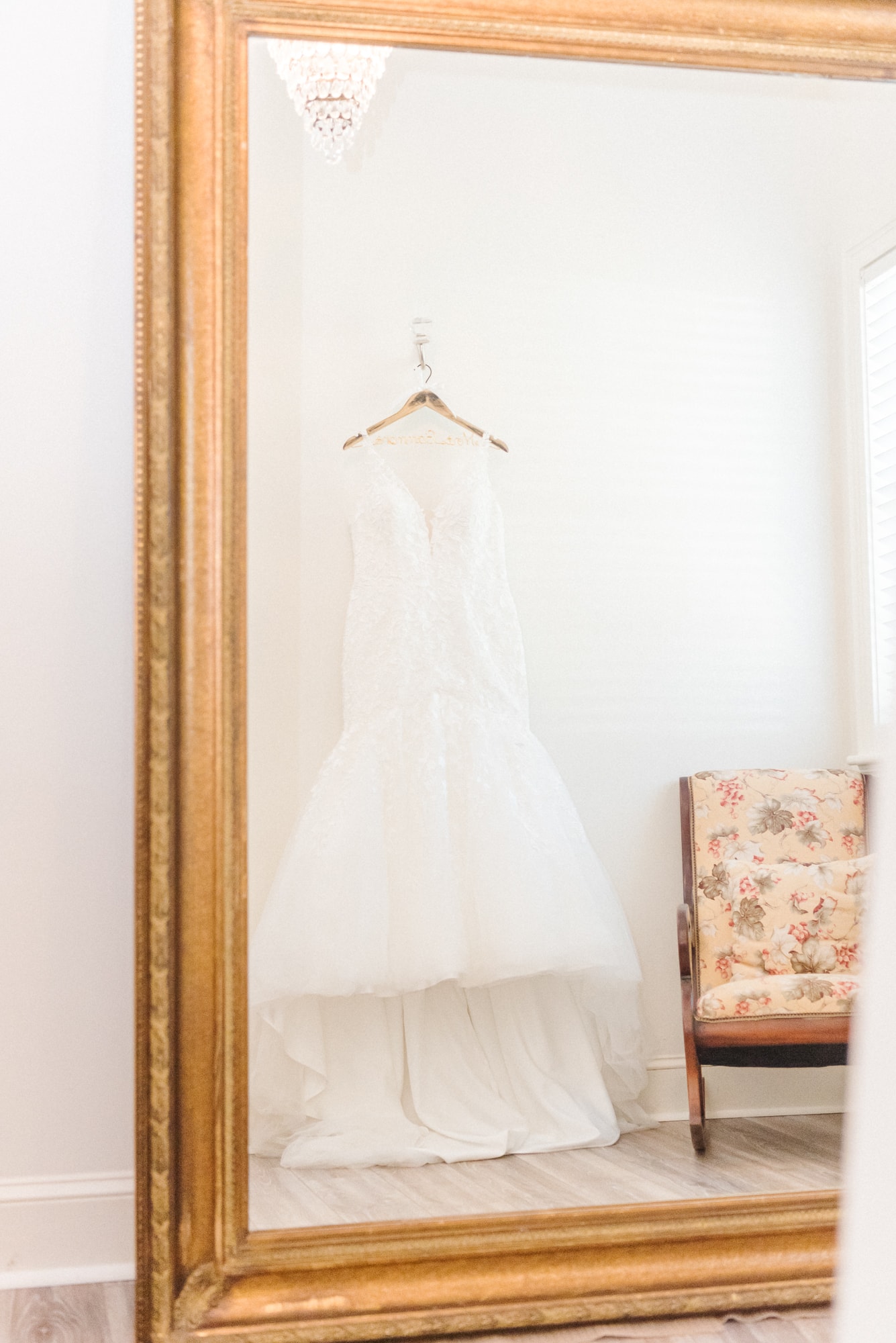 The bride's dress hangs off the wall, reflected in the mirror of Low Meadows Estate.