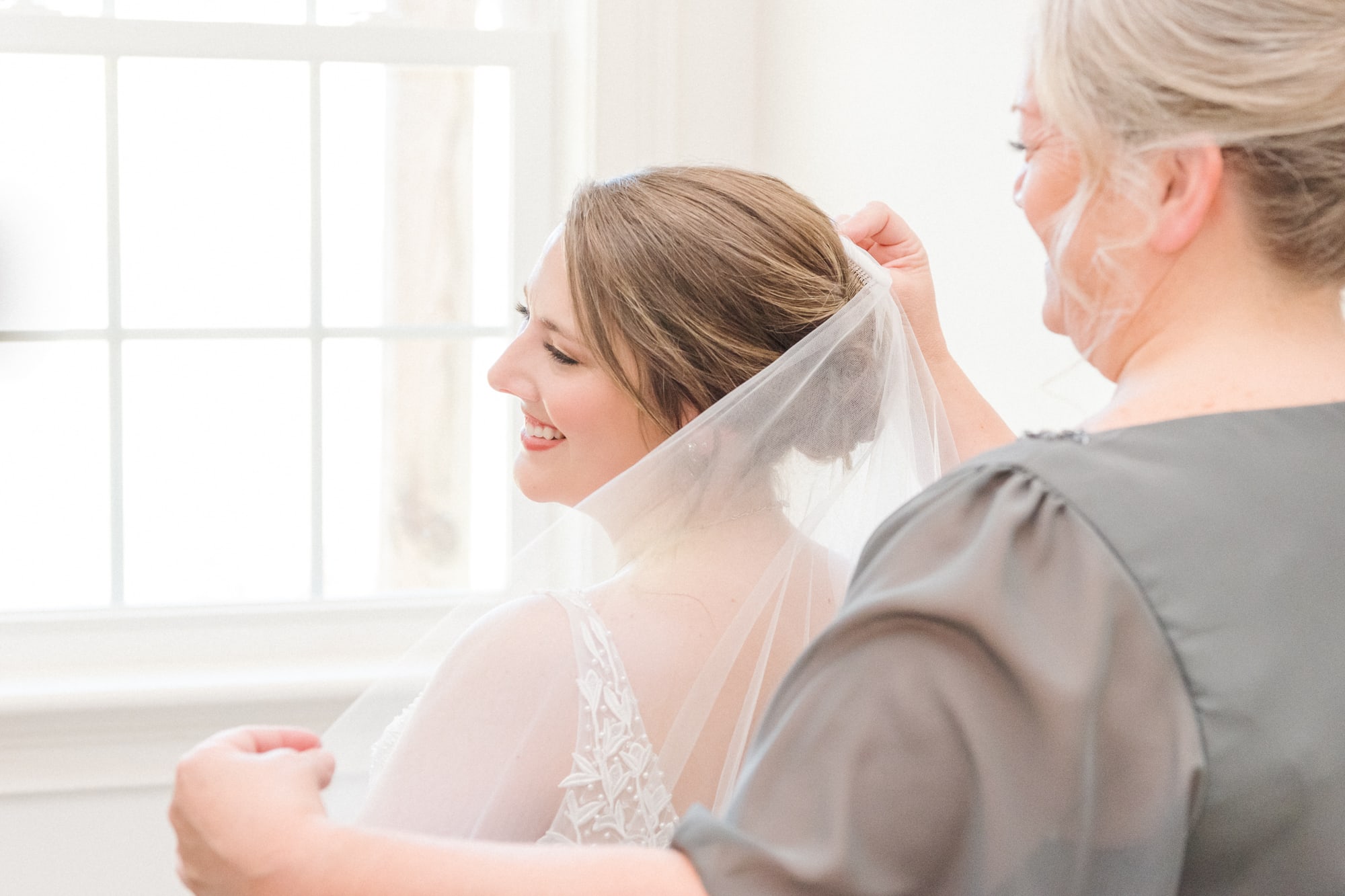 Katelynn's mom helps secure her veil in the bride's room of Low Meadows Estate.