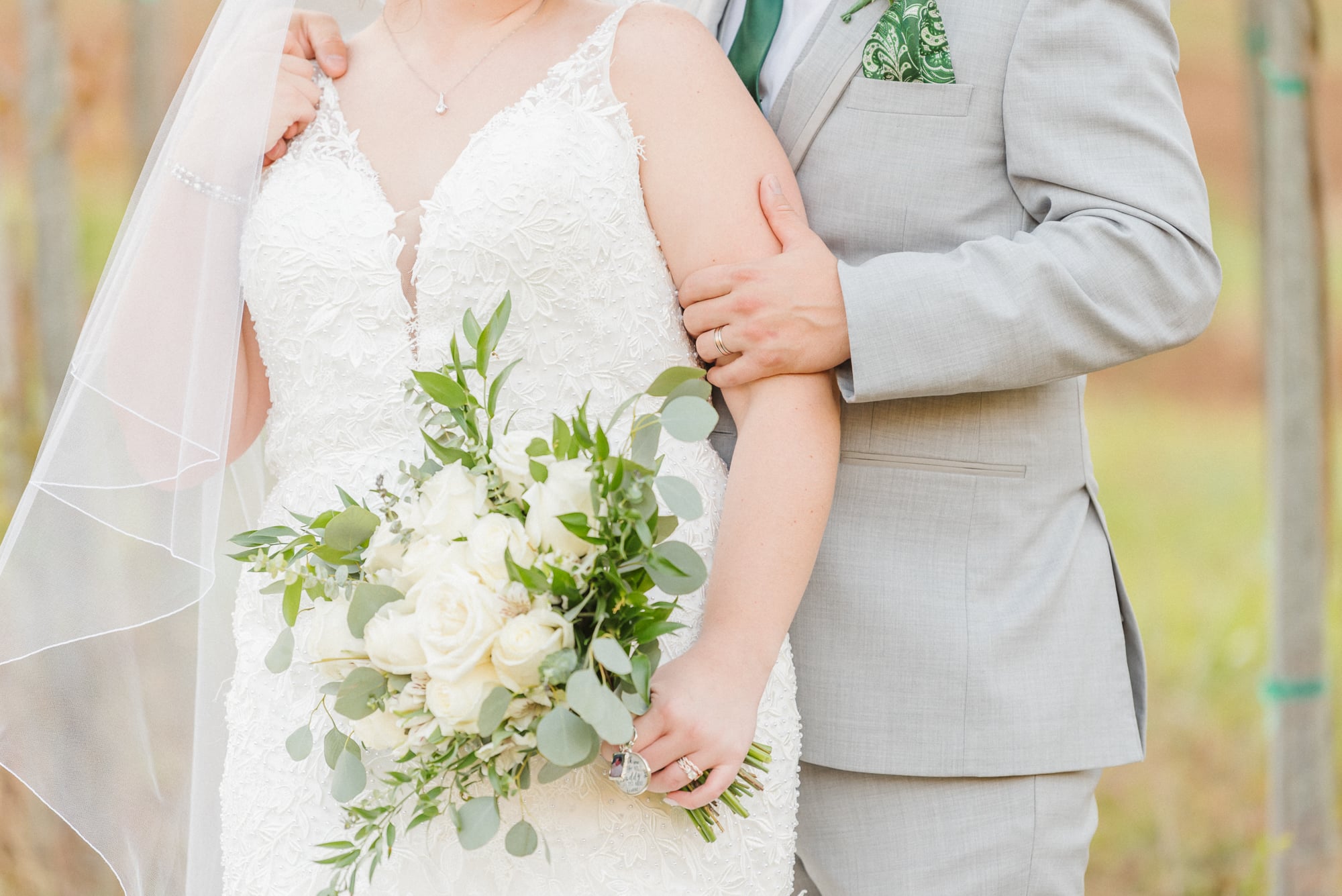 A close up of the bride's bouquet as the bride and groom hold each other after their ceremony at Low Meadows Estate.