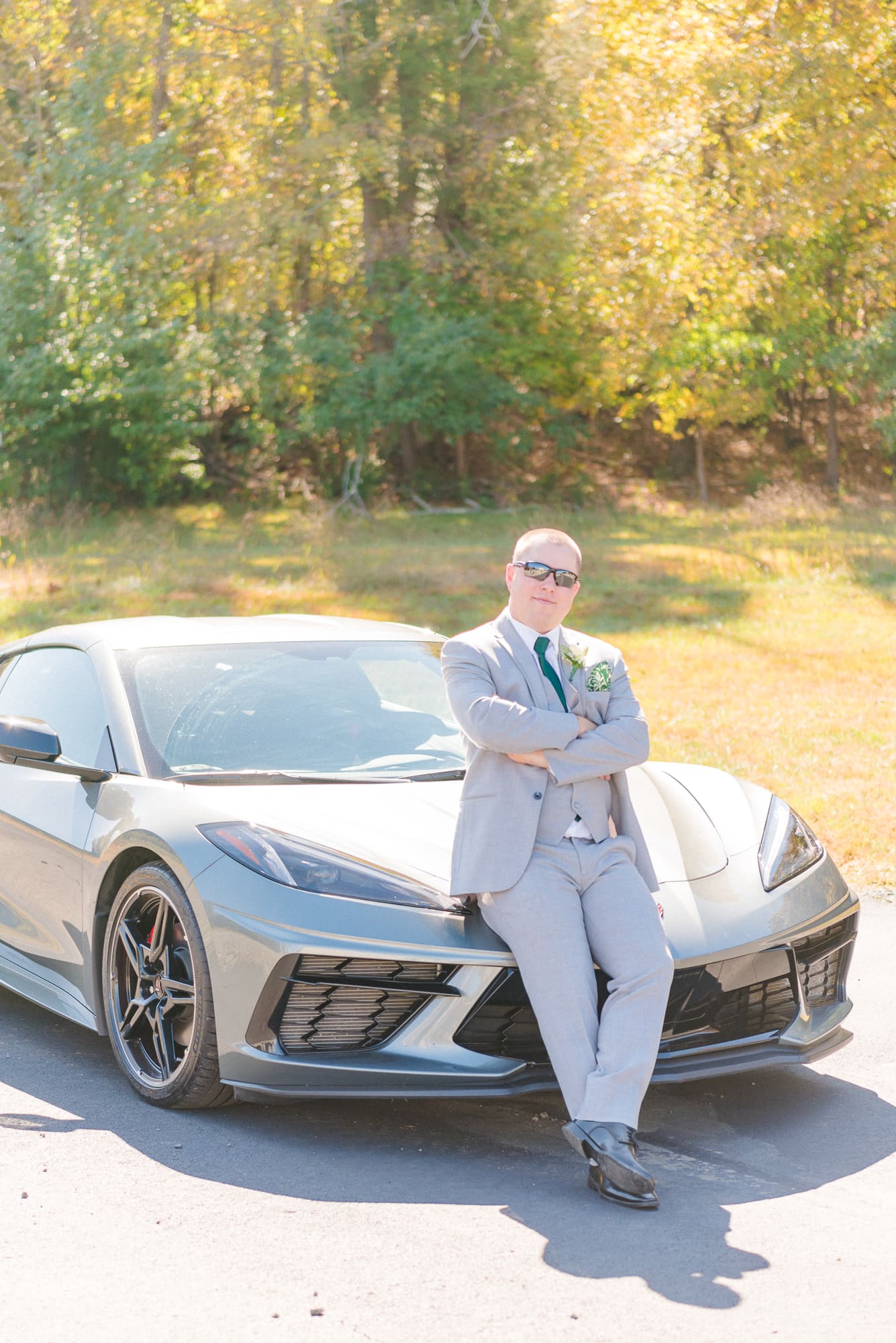 Alec sits on the hood of his new car before his wedding at Low Meadows Estate.