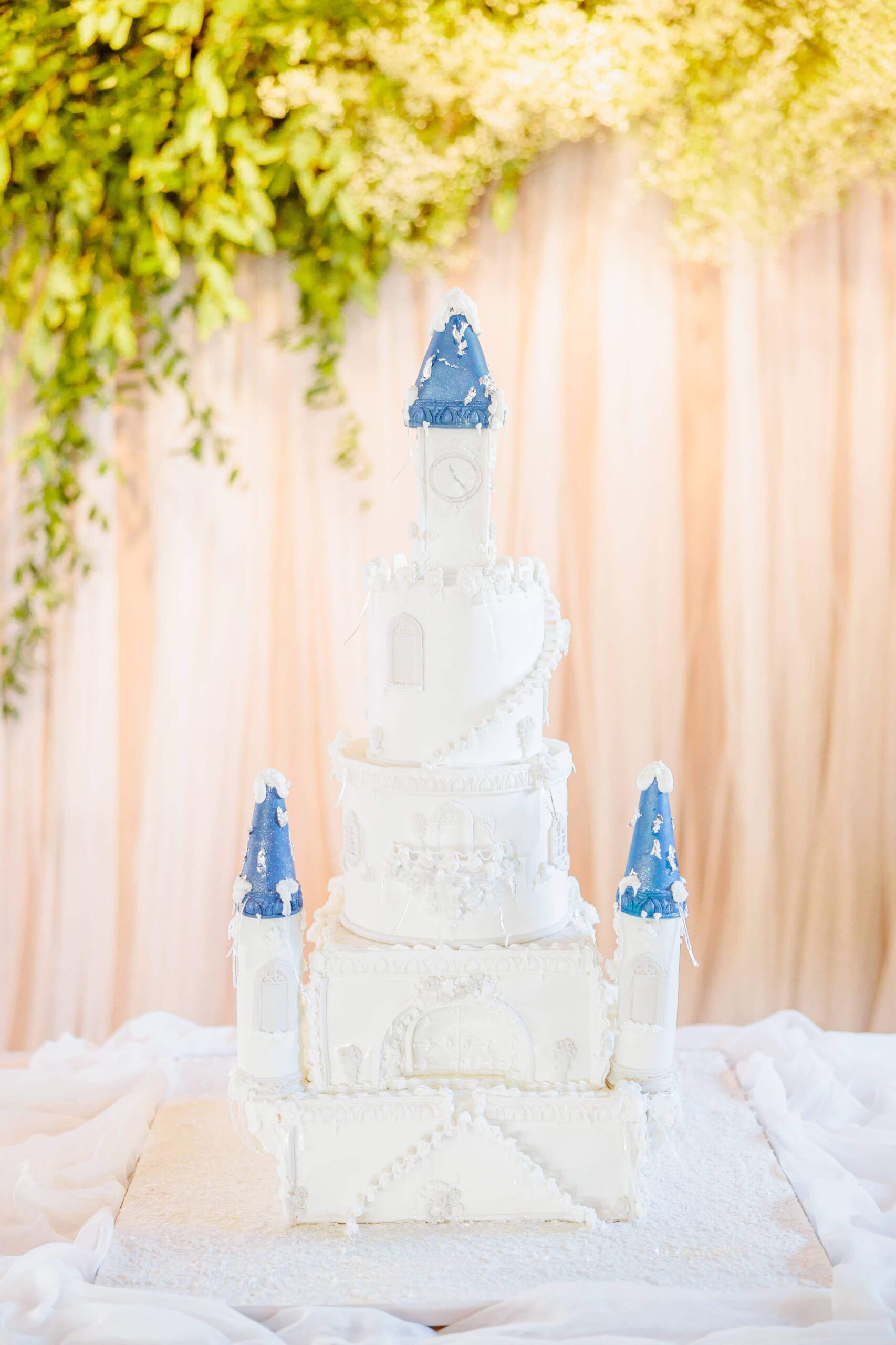 A winter wonderland wedding cake made to look like an icy castle, with turrets and intricate swirl details.