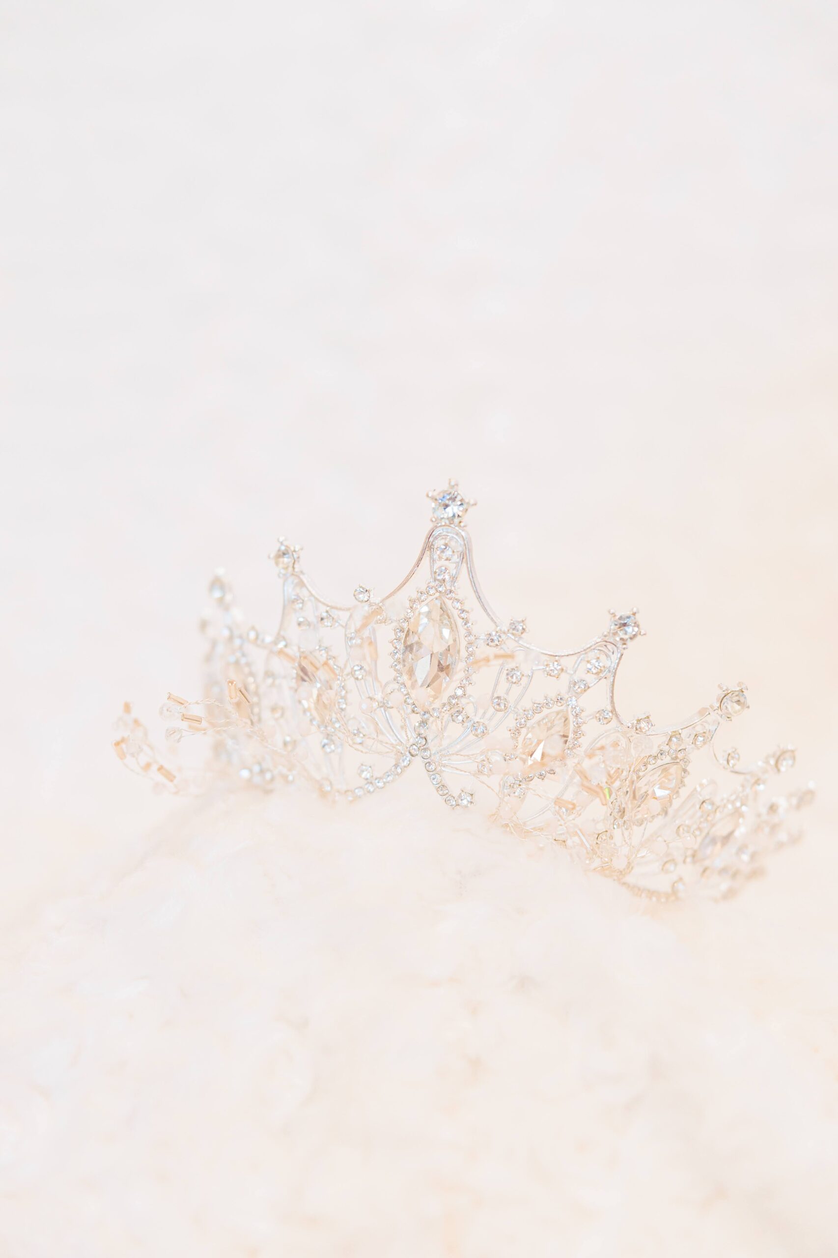 A winter wonderland wedding tiara sits on the fuzzy white bridal shawl.