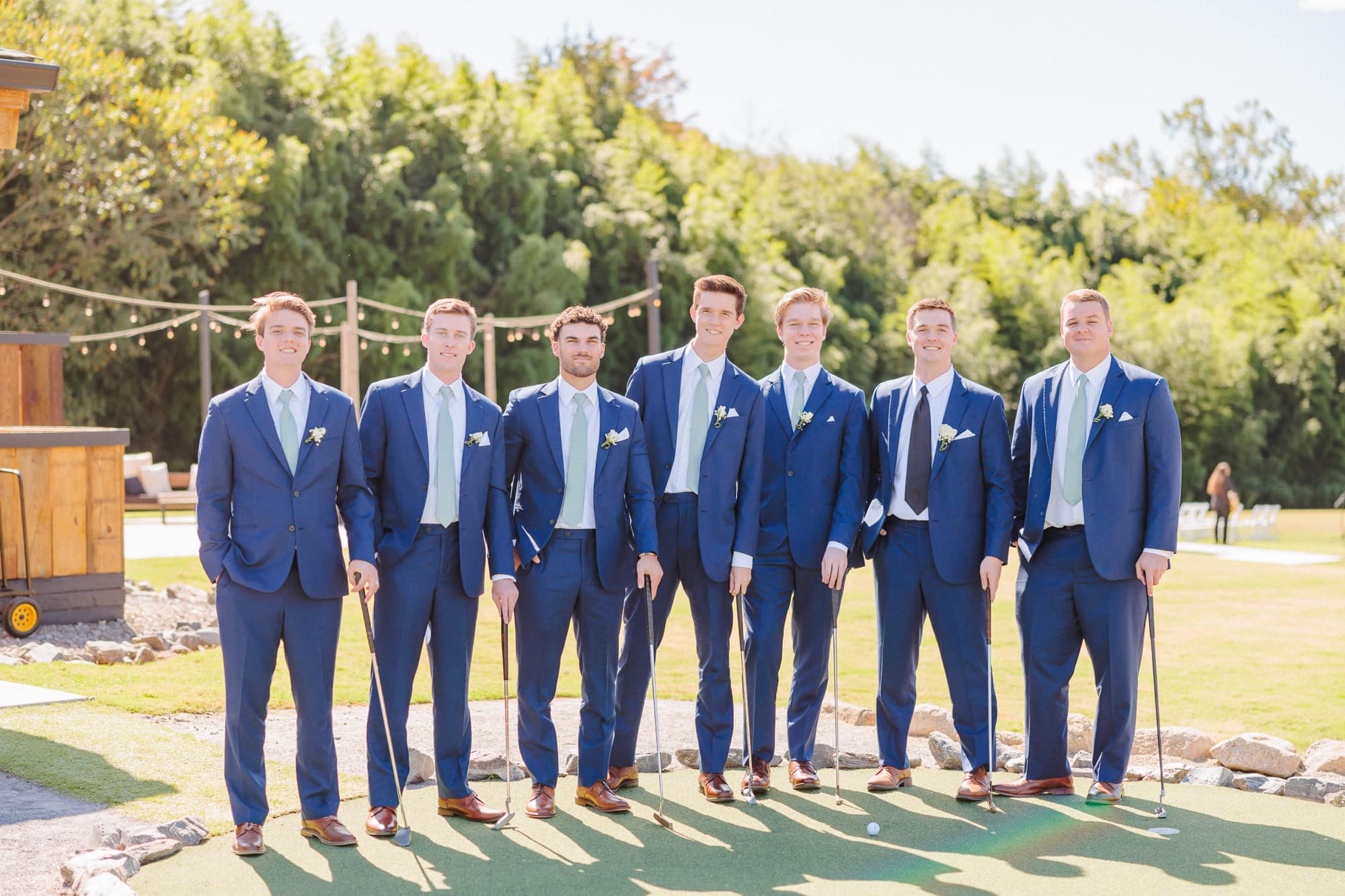 Conor and his groomsmen enjoy the mini golf course at the barn wedding venue.