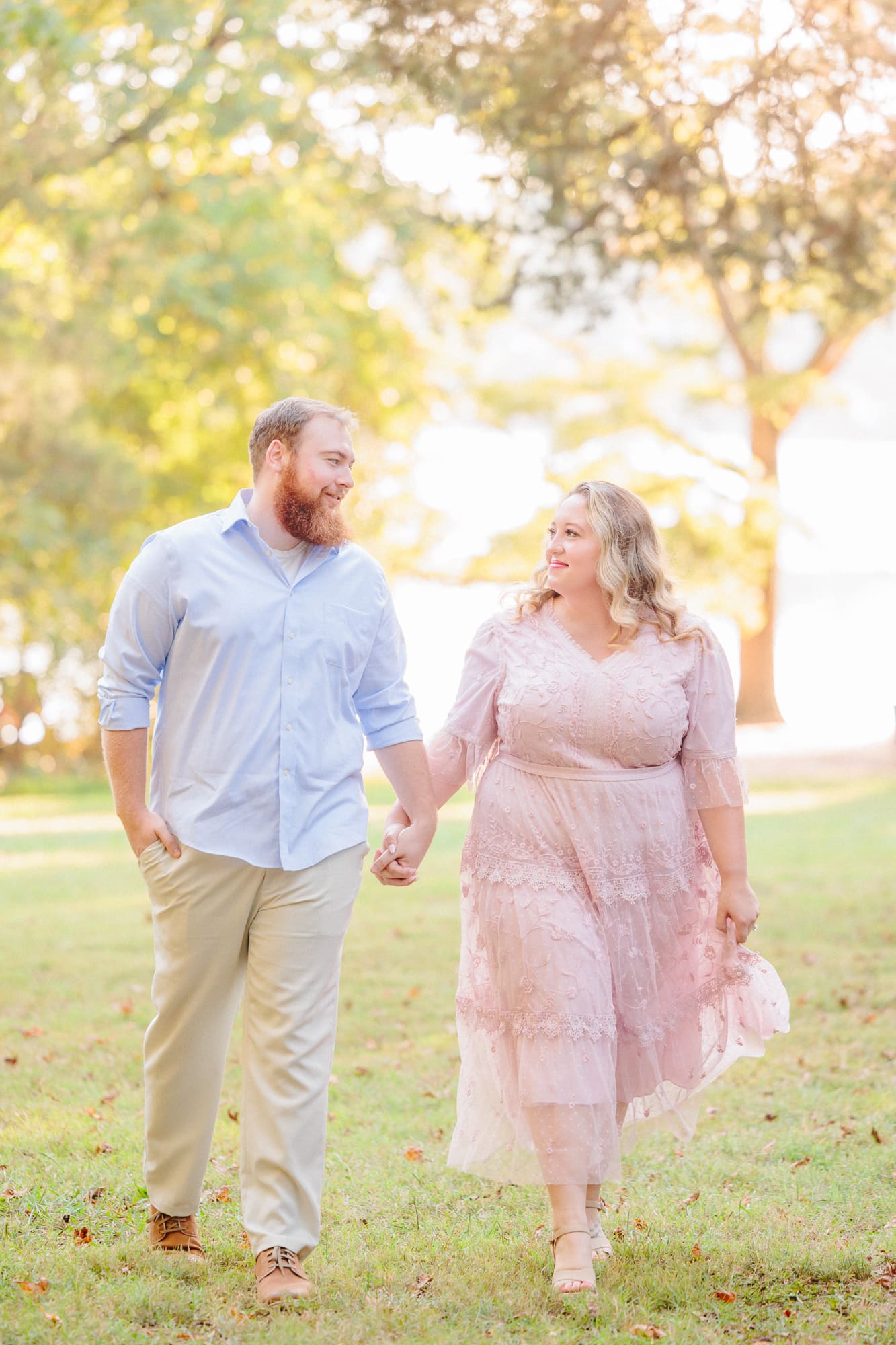 Shawn and Shelby walk hand in hand at the Latta Nature Preserve during their Huntersville engagement session.