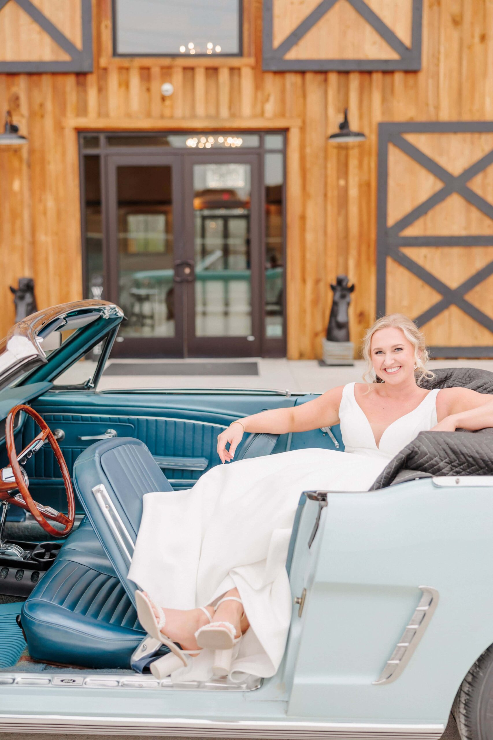 Bailey sits in the back seat of her classic car for bridal portraits.