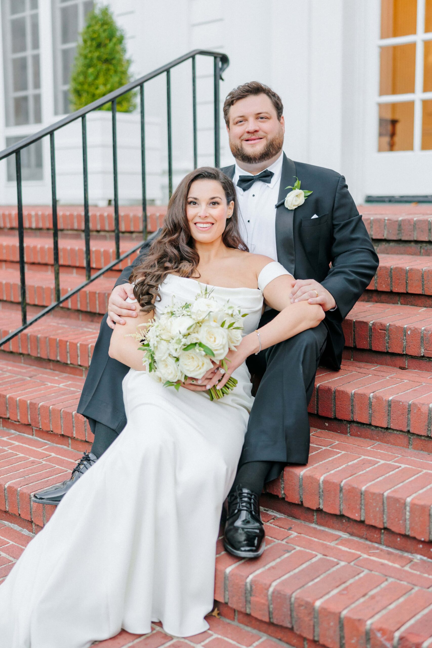 In front of the Duke Mansion, Meg and Tyler smile for their wedding photos.